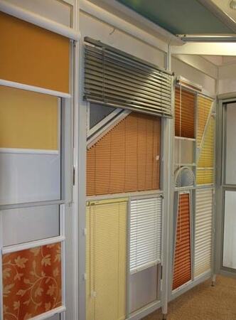 Verschiedene bunte Jalousien und Plissees als Muster in einer Ausstellung für Sonnenschutz.