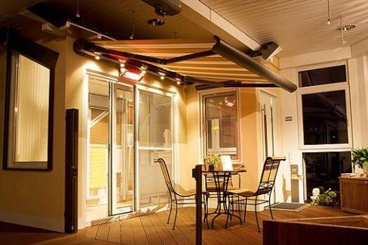 Beleuchtete Terrasse mit Markise, modernen Gartenmöbeln und gemütlicher Atmosphäre im Abendlicht.